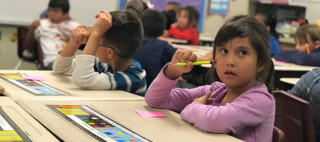 Student holding pencil in classroom