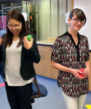 Two teachers smiling doing an activity